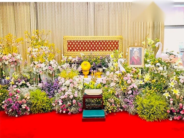 ดอกไม้หน้ารูปจัดเป็นฐานเตี้ยบนโต๊ะหมู่บูชา ติดตั้งถึงศาลาโดย Funeral Decor